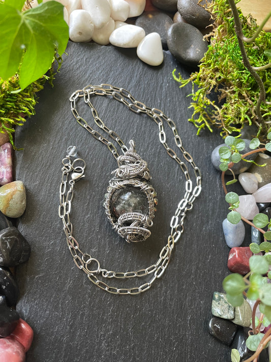 Image of a crystal ball amulet in stainless steel wire wrap
