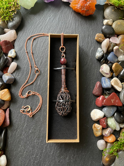 Necklace with a decorative clasp in a box on a stone surface