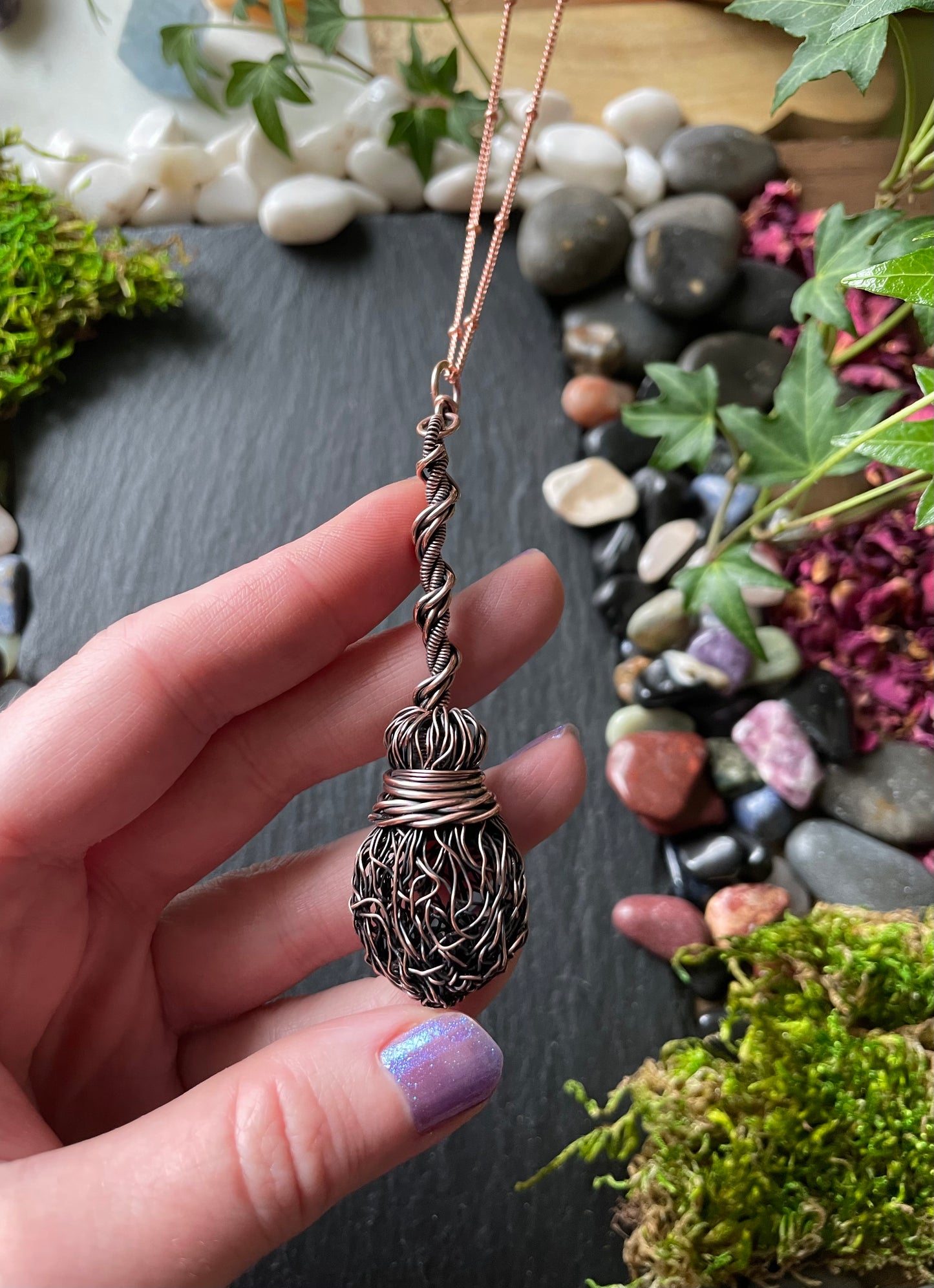 Image of an antiqued copper miniature witch broom pendant with double twisted handle