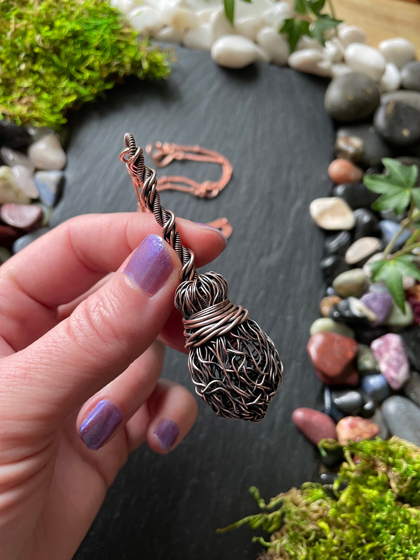 Image of an antiqued copper witch broom pendant with double twisted handle