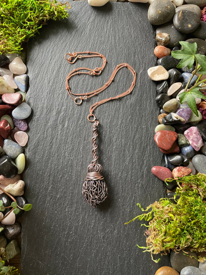 Image of an antiqued copper miniature witch broom pendant with double twisted handle