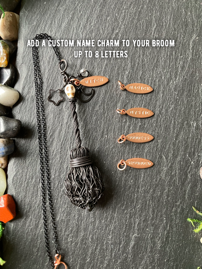 A dark metal broom pendant necklace with custom name charm, displayed on a dark slate background with five example copper-colored name charms and overlaid text explaining customization.