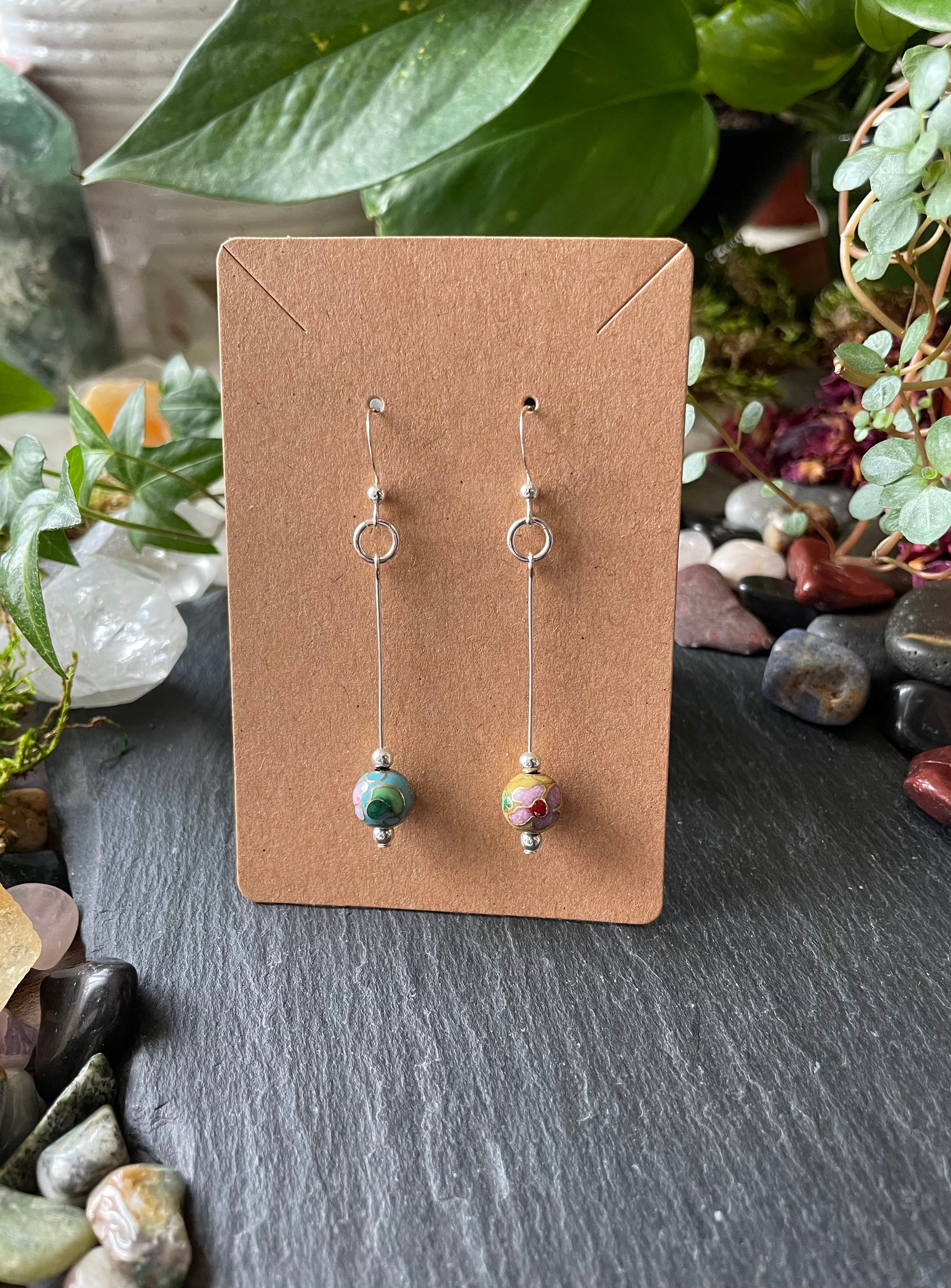 Pair of earrings on a brown card with a natural background