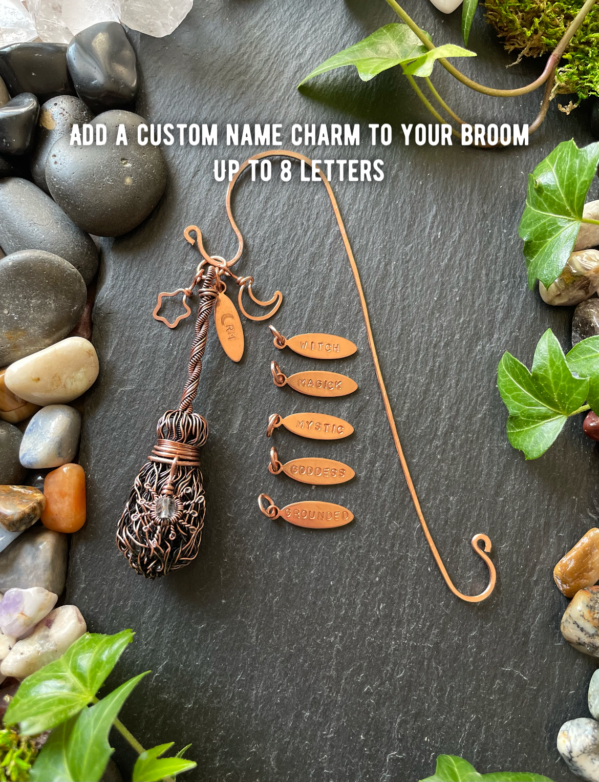 Decorative broom with customizable name charms on a stone surface with plants.