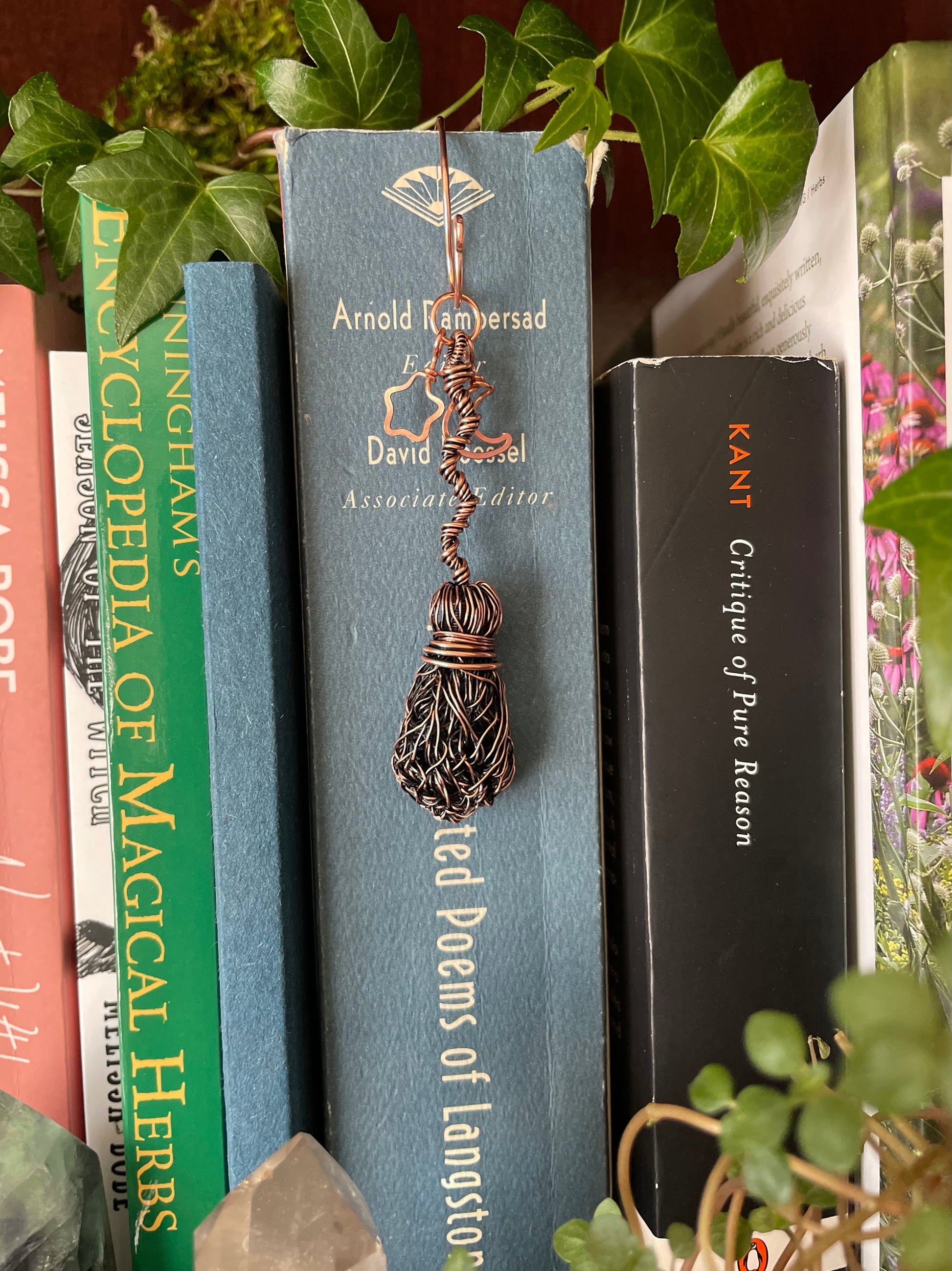 Decorative bookmark in a book on a shelf with plants in the background
