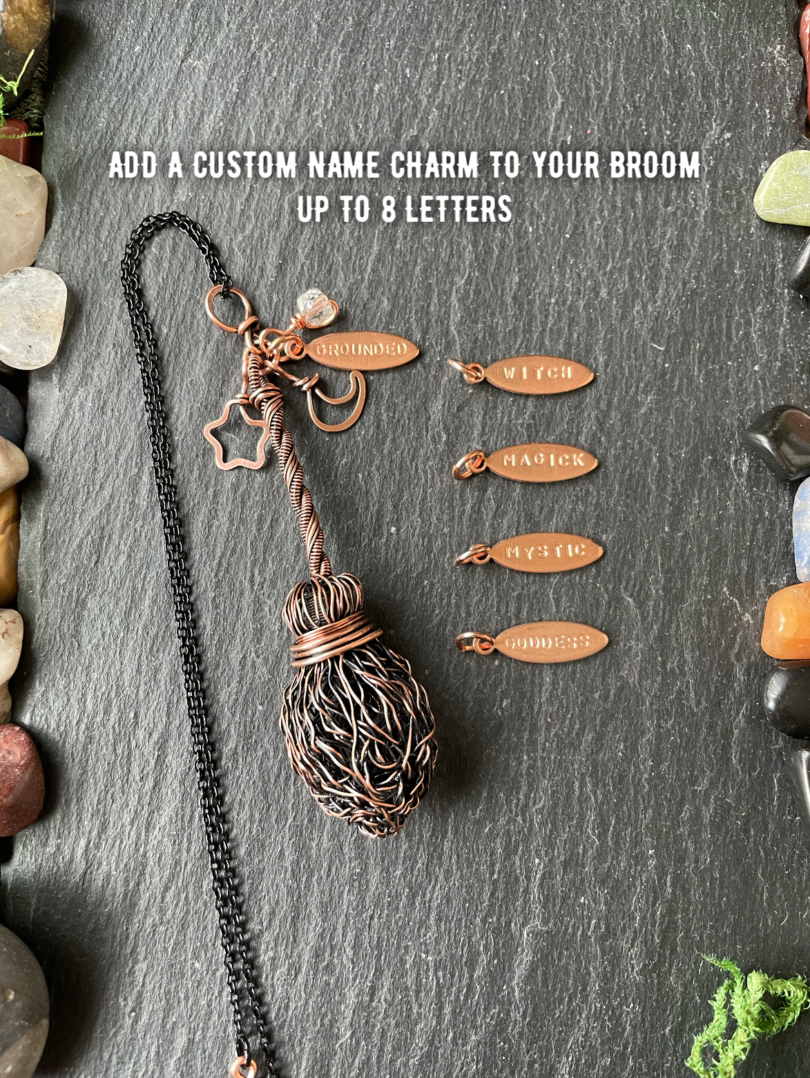 A handmade copper wire broom pendant, displayed on a dark slate background with decorative stones. White text at the top reads 'ADD A CUSTOM NAME CHARM TO YOUR BROOM UP TO 8 LETTERS'.