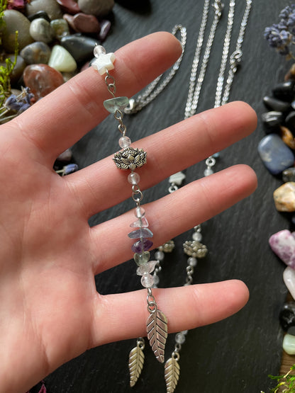 Car charm with fluorite crystal beads, lotus flower bead, and silver leaf charm displayed in hand