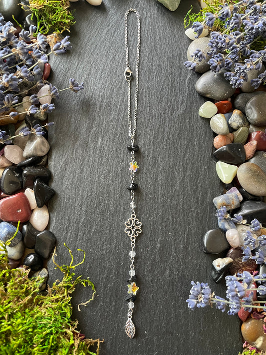 A car charm with obsidian beads, star beads, and leaf charms