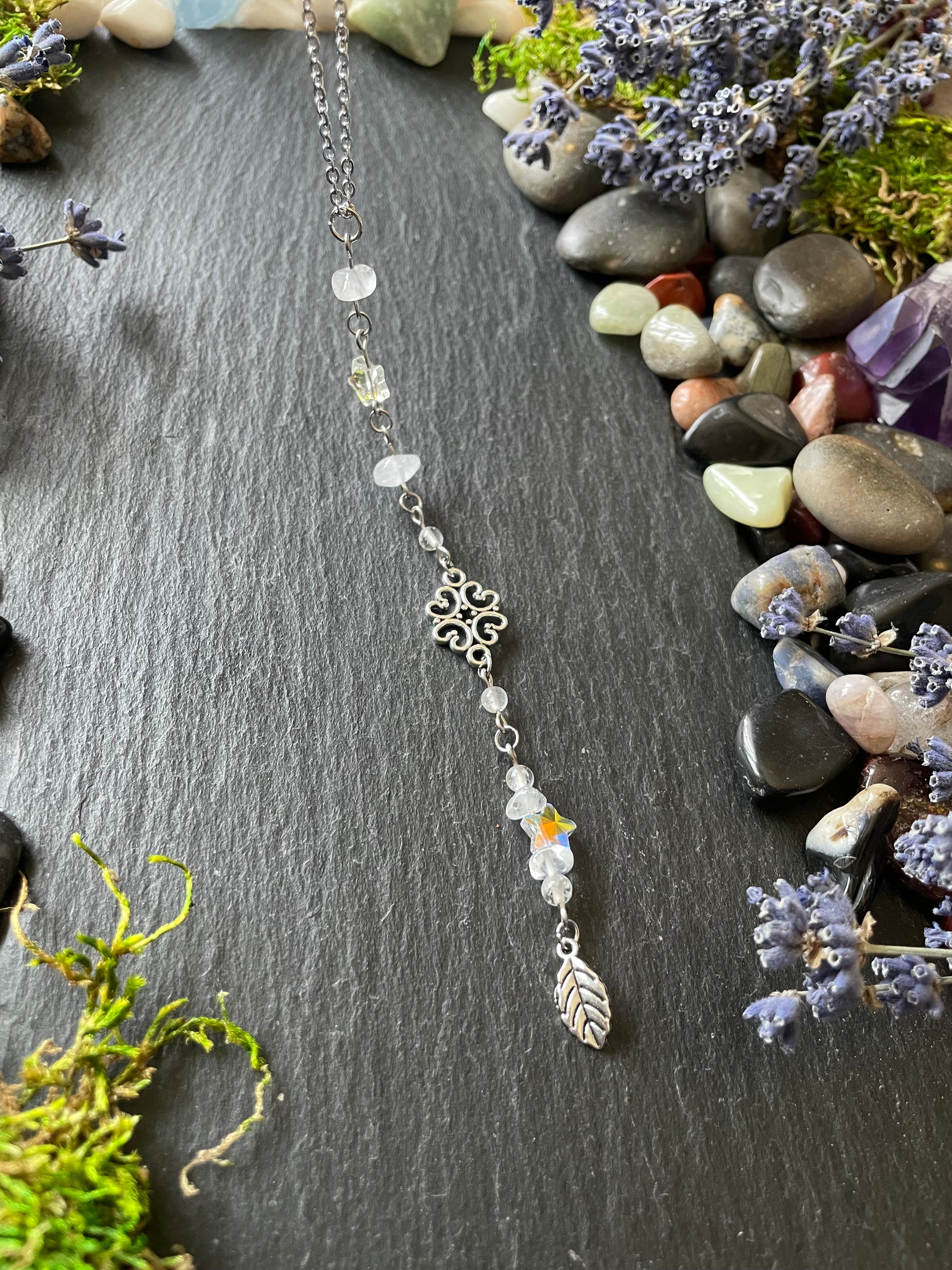A crystal car charm with quartz crystal beads, star charms, and a leaf charm