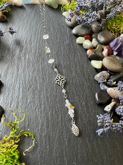 A crystal car charm with quartz crystal beads, star charms, and a leaf charm