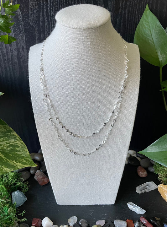 Necklace on a mannequin bust with a natural stone and leaf background