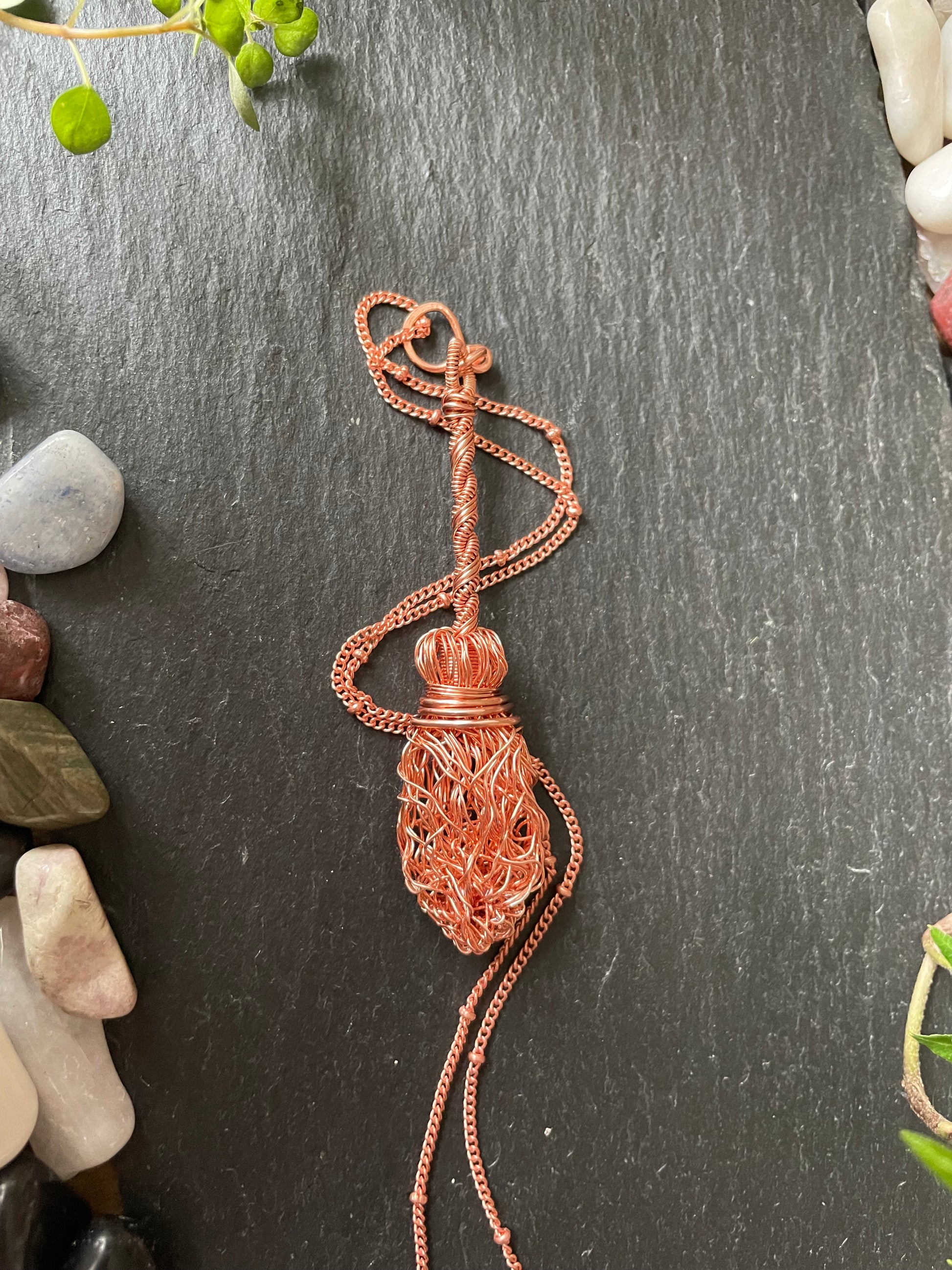 Image of a copper wire broom pendant necklace