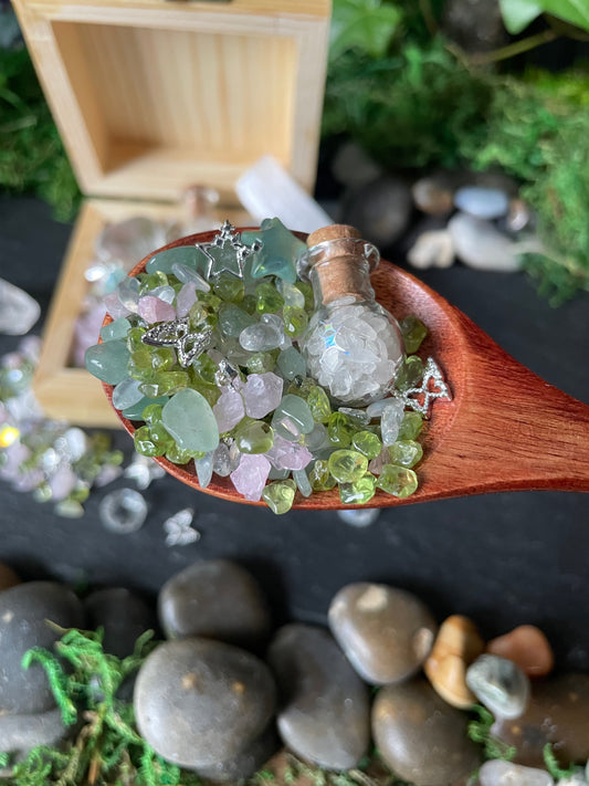 Wooden spoon filled with colorful gemstones against a natural stone background