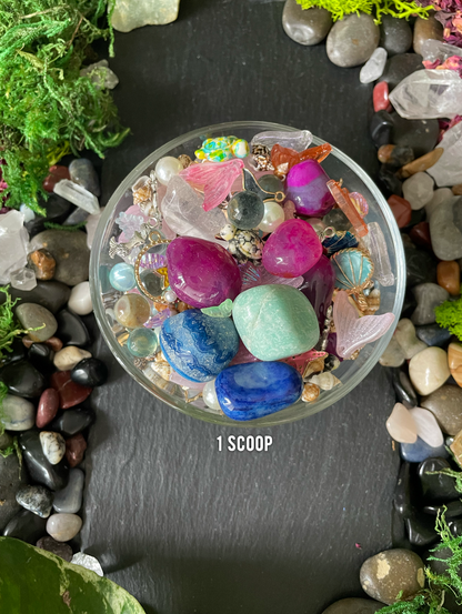 Small container filled with colorful stones on a bed of pebbles and moss.