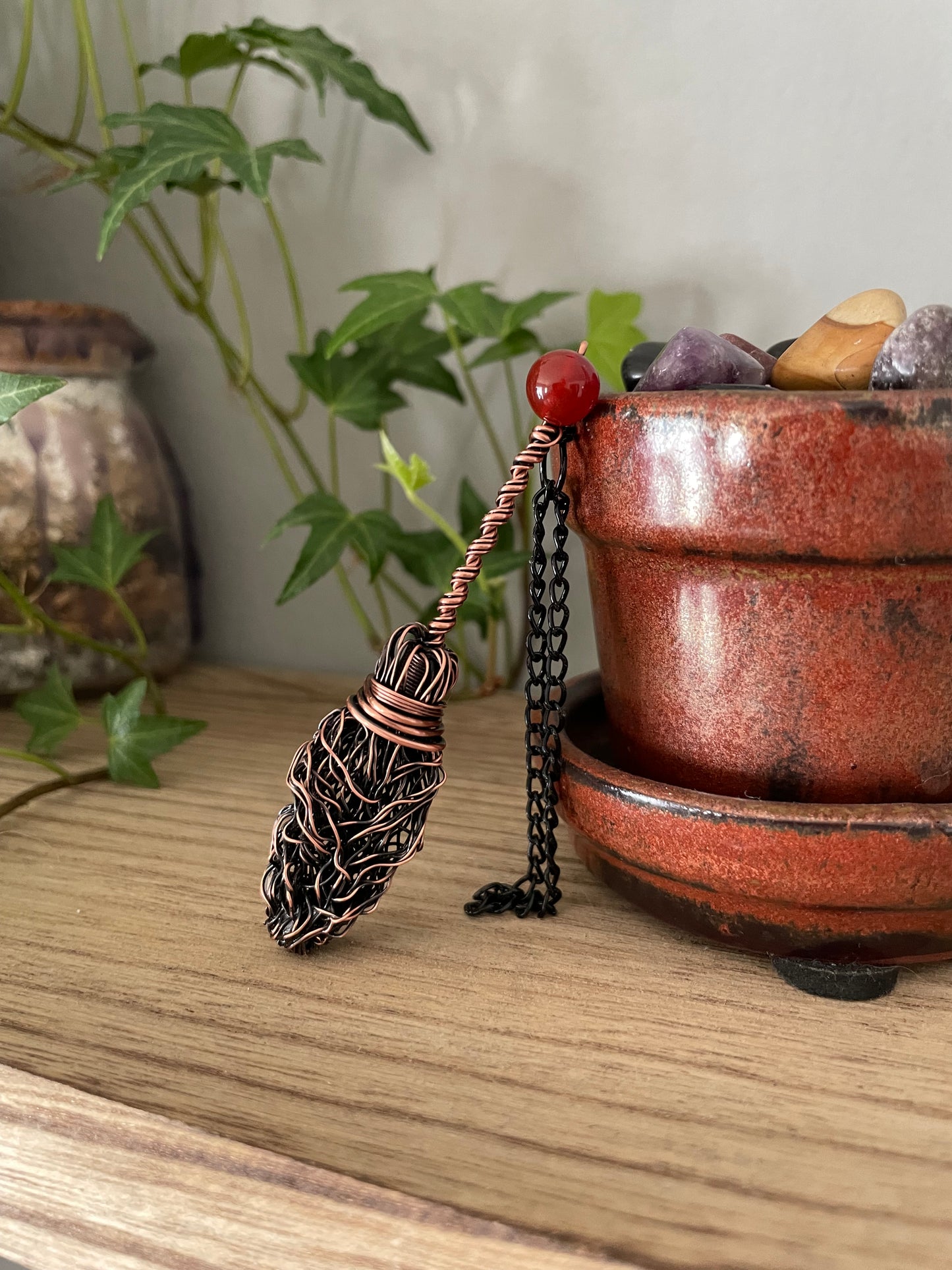 Image of miniature copper broom with carnelian bead