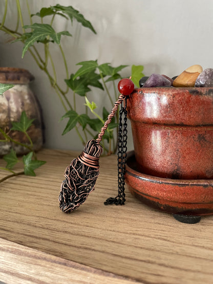 Image of miniature copper broom with carnelian bead