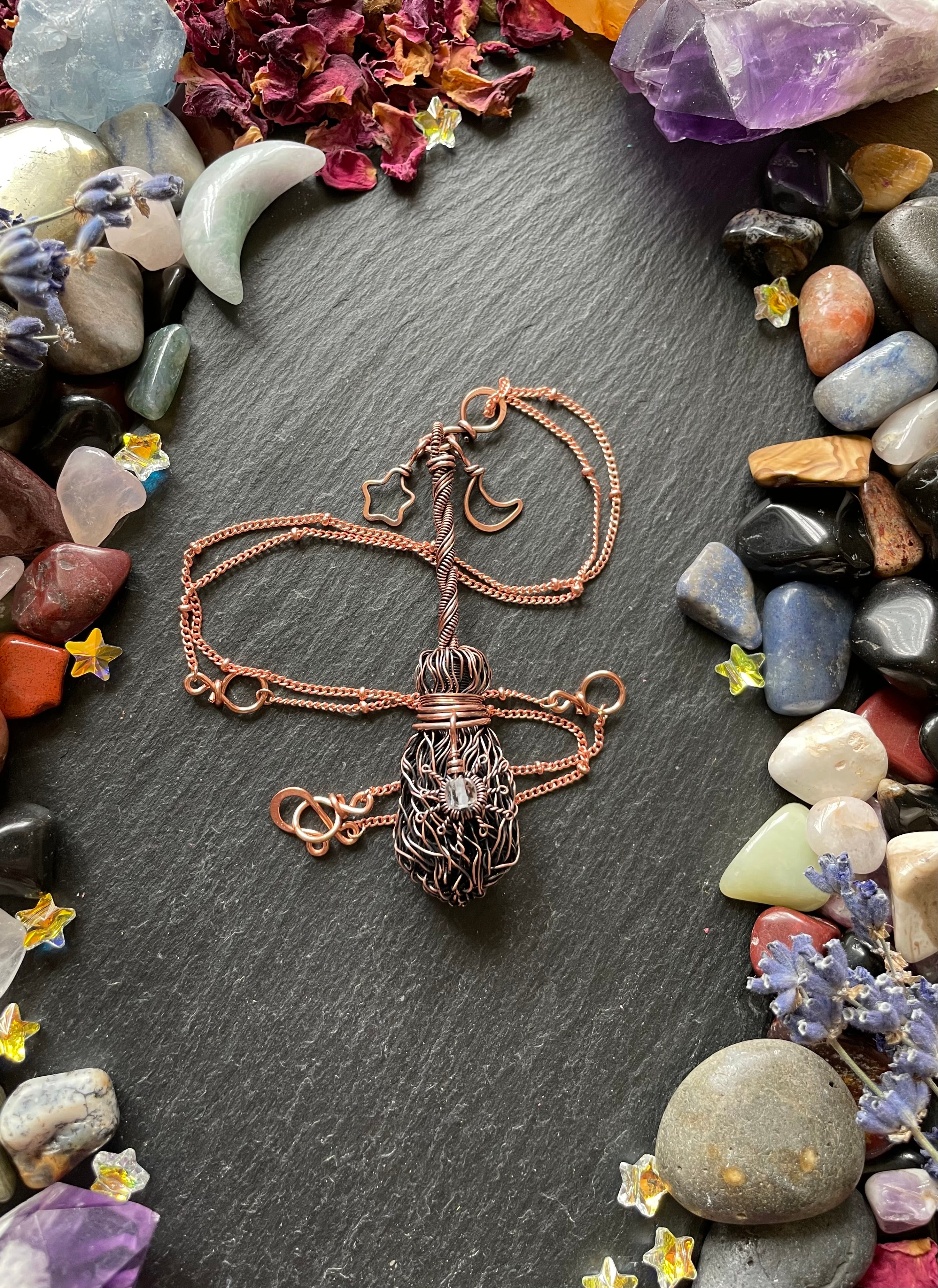 Miniature wire broom pendant with sun, star, and moon charm, attached to a copper chain with star charms around it