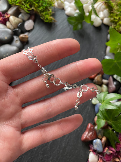 Silver bracelet on a hand with a natural background of stones and plants