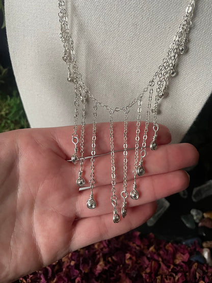 Silver chains displayed on a hand with a neutral background