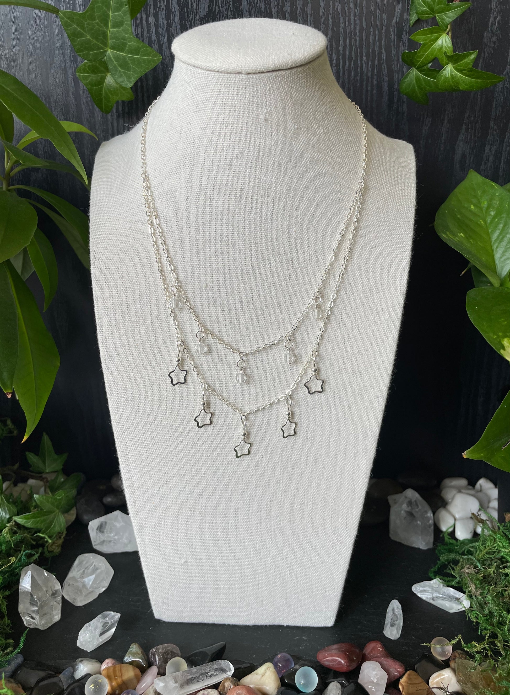 Necklace on a mannequin bust with crystals and plants in the background