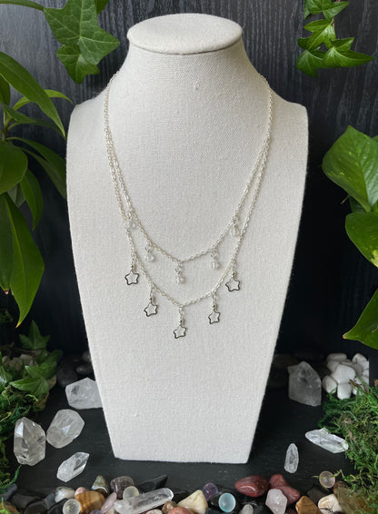 Necklace on a mannequin bust with crystals and plants in the background