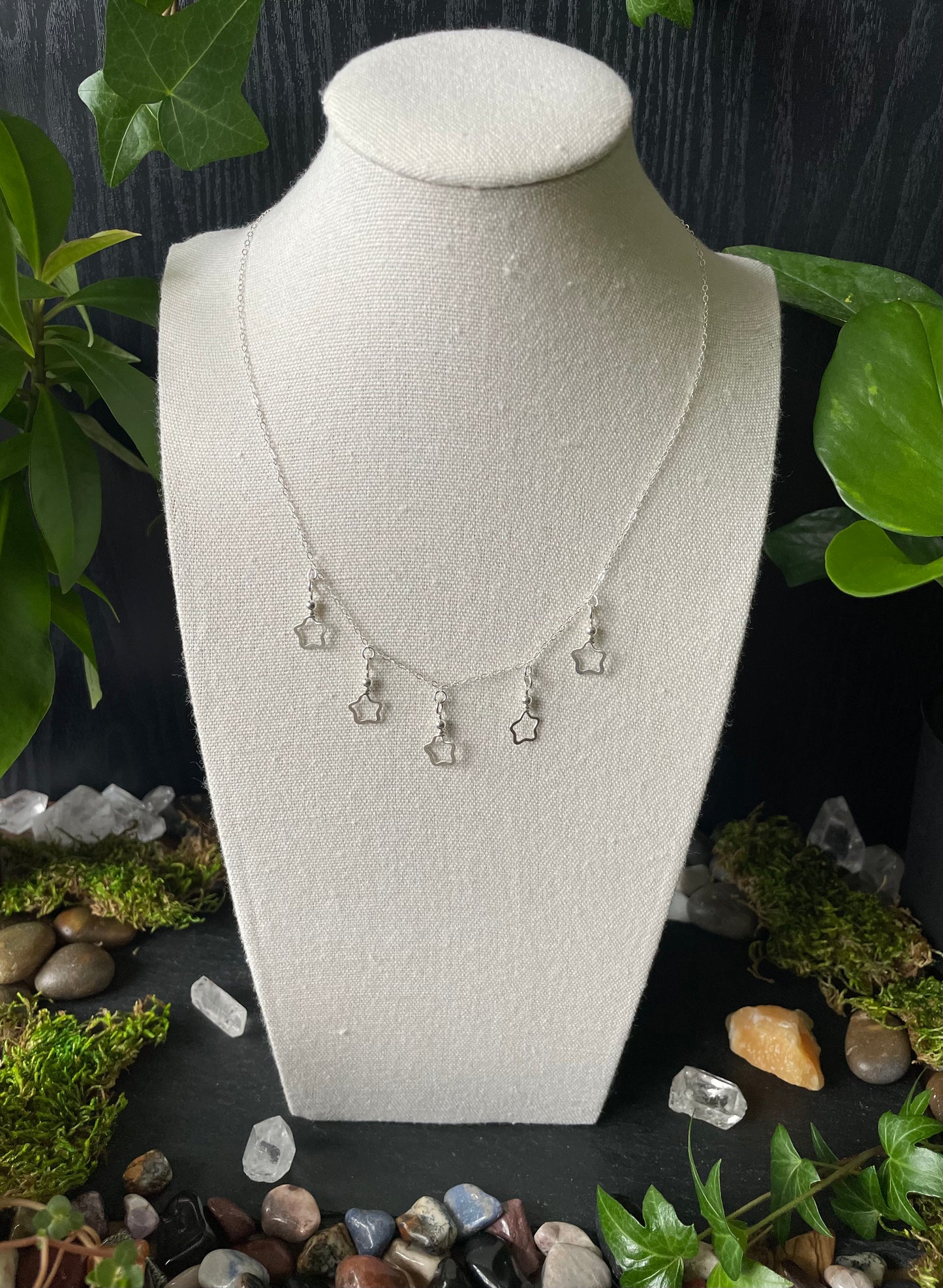 Necklace on a white bust with a natural stone and leaf background