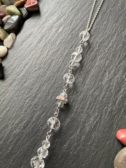Car mirror charm with clear beads on a dark slate surface