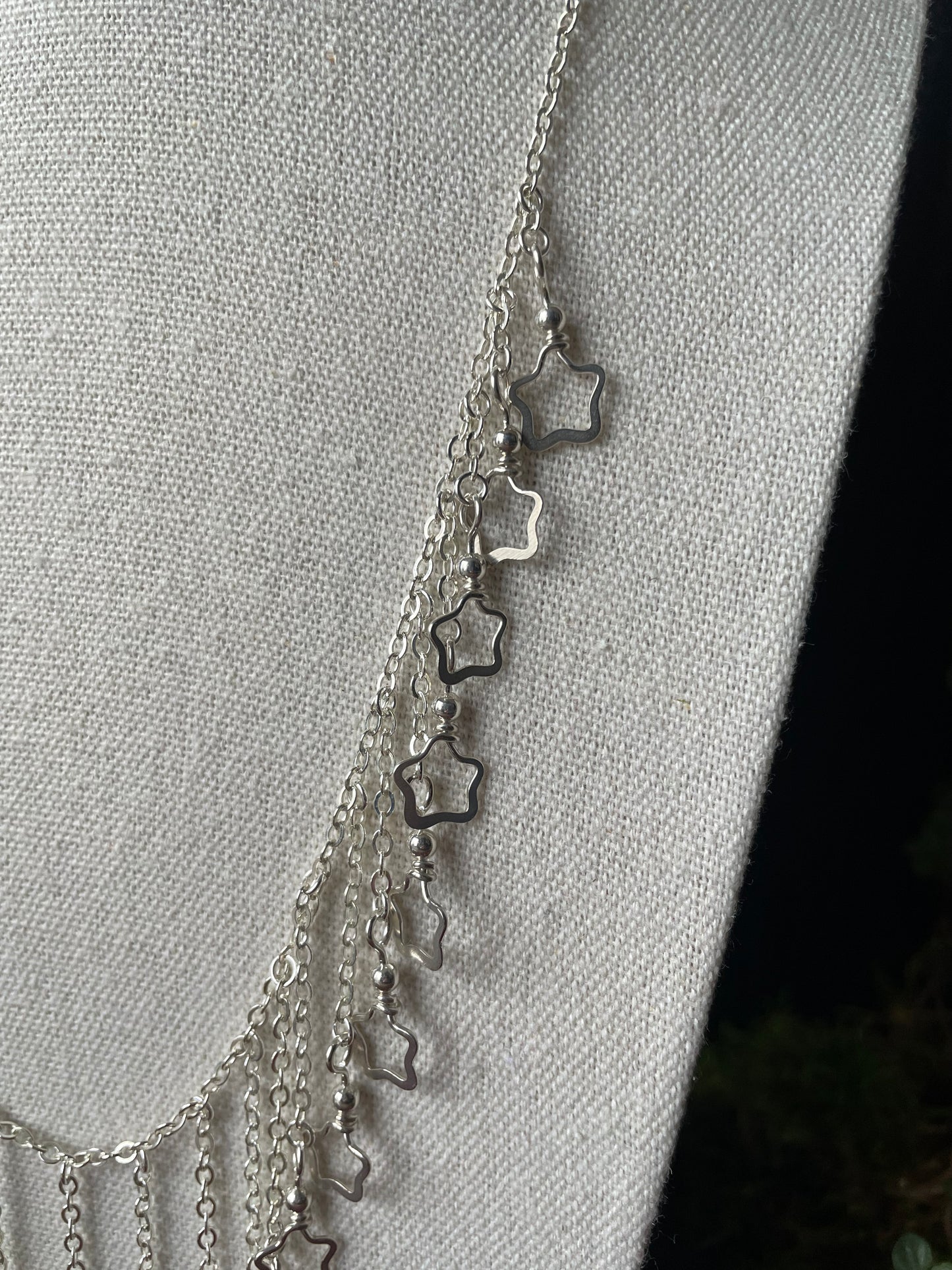 Image of a closeup of the silver star charms on a necklace
