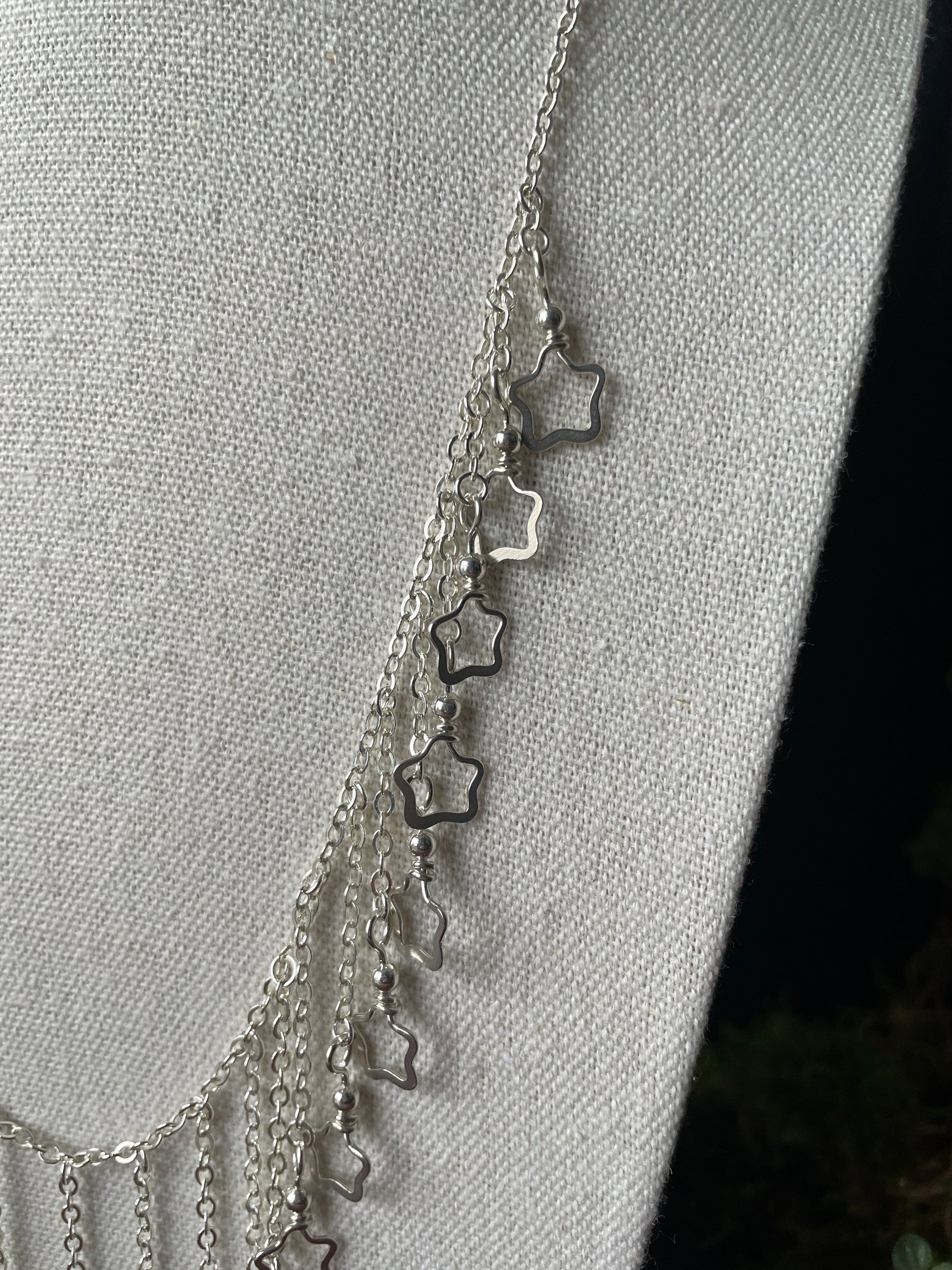 Image of a closeup of the silver star charms on a necklace