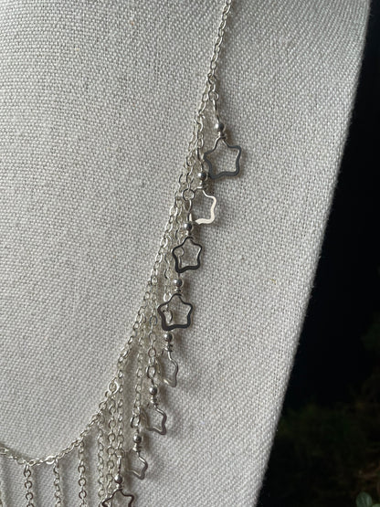 Image of a closeup of the silver star charms on a necklace