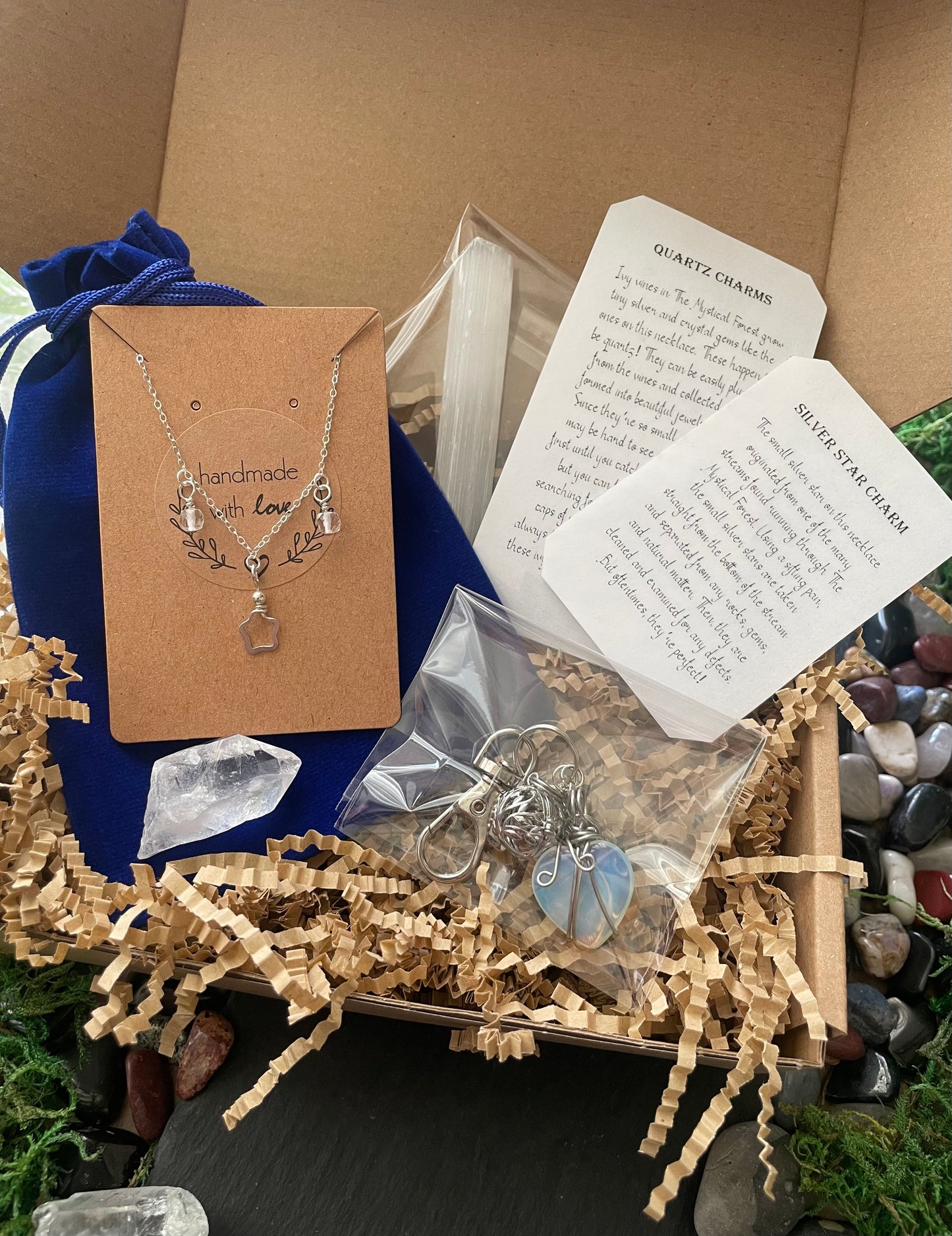Jewelry set with necklace and keychain in a box with packaging materials and cards.