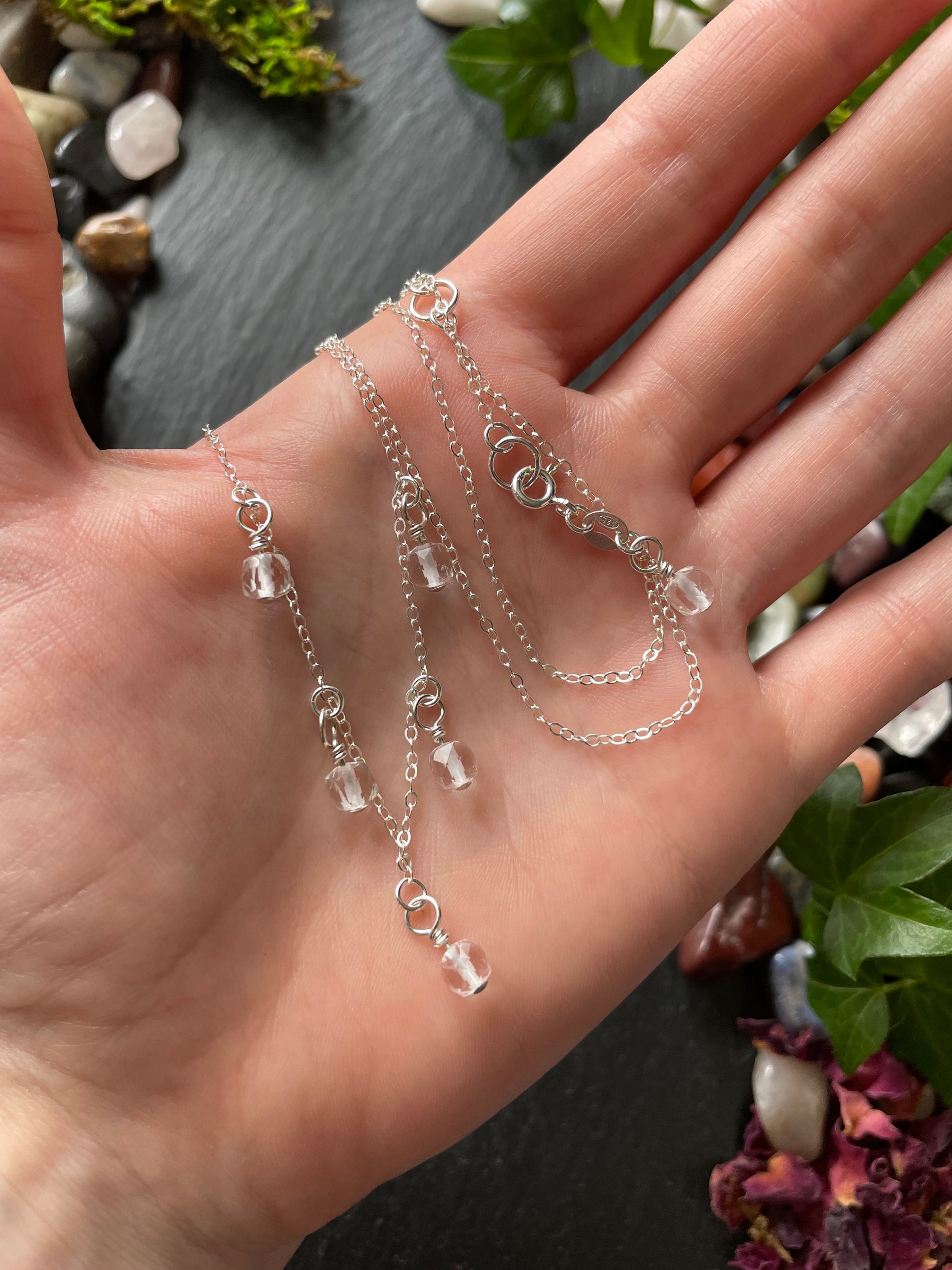 Silver chain necklace on a hand with a natural background