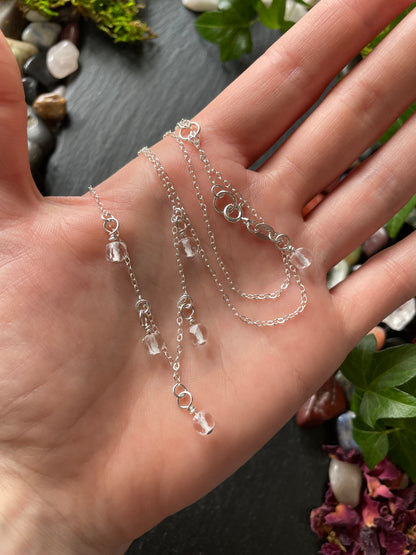 Silver chain necklace on a hand with a natural background