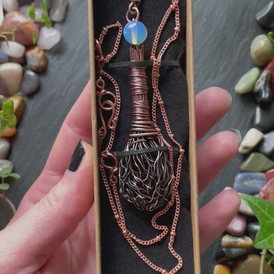 A miniature broom pendant with an opalite bead