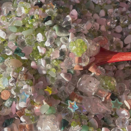 Spoon scooping colorful crystal chips out of wooden bowl