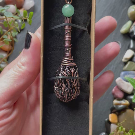 A miniature broom pendant with a green aventurine bead
